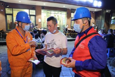 為各個(gè)攤位檢查用電安全情況、排查隱患、發(fā)放用電安全宣傳單